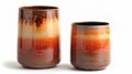 A pair of cylindrical vases with a dipdyed glaze effect featuring a blend of dark and light shades of orange creating a