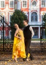 Pair of dancers dancing in the woods. Man with suit, woman in yellow long dress middle of the palace park in autumn. Dry fallen c Royalty Free Stock Photo