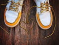 A pair of deck shoes on a nice wooden porch with the laces in a heart shape