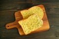 Pair of Delectable Homemade Garlic Butter Whole Wheat Toasts on Wooden Breadboard