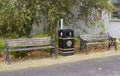 A pair of dilapidated park benches and a city council litter bin on the roadside in the small mill village of Edenderry in South B