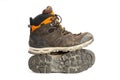 Pair of dirty brown/orange men`s hiking boots with white background. Royalty Free Stock Photo