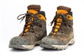 Pair of dirty brown/orange men`s hiking boots with white background. Royalty Free Stock Photo