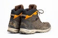 Pair of dirty brown/orange men`s hiking boots with white background. Royalty Free Stock Photo