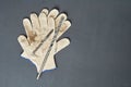 Pair of dirty textile protective gloves for repair or other hard works near old messy drills
