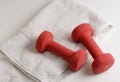 A pair of dumbells and white towel