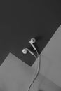 Pair of in-ear headphones on dark black and white background. Royalty Free Stock Photo