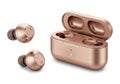 A pair of earbuds and a copper color case AI Generated