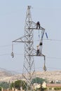 Workers over a high tension tower making reparations. Royalty Free Stock Photo