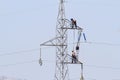 Workers over a high tension tower making reparations. Royalty Free Stock Photo