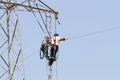 Workers over a high tension tower making reparations. Royalty Free Stock Photo