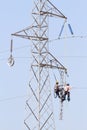 Workers over a high tension tower making reparations.