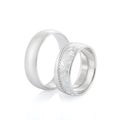 Pair of elegance wedding silver rings isolated on white background. Womens ring with white enamel, diamonds and floral design