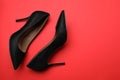 Pair of elegant black high heel shoes on red background, flat lay. Space for text Royalty Free Stock Photo