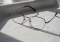 A pair of eyeglasses with thin metal frames rests on a textured Royalty Free Stock Photo