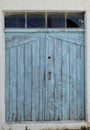 Old blue window shutters with broken glass above Royalty Free Stock Photo