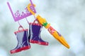 Pair of fashion rubber child boots hanging with yellow umbrella