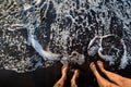 A pair of feet on the black sand near the ocean, Tenerife, Spain, Canary Islands