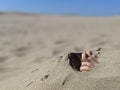 A pair of feet and toes sticking out of beach sand no grass Royalty Free Stock Photo