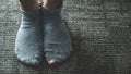 A pair of feet wearing old, dirty, and torn socks Royalty Free Stock Photo
