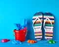 pair of female beach striped slippers, red plastic baby bucket Royalty Free Stock Photo