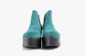 Pair of female cyan leather boots on white background.