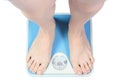 A pair of female feet standing on a bathroom scale Royalty Free Stock Photo