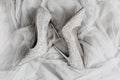 Pair female pointy-nosed silver shining holiday shoes on Ultimate Gray color tulle fabric, holiday layout, selective focus