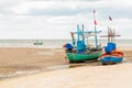 Pair of fishing boats stand on a shallow against the low tide of the ocean with copy space Royalty Free Stock Photo