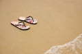 A pair of flip flops on the beach sand, Summer back concept. Royalty Free Stock Photo