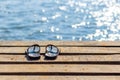 Pair of flip flops on the wooden dock and scenery of lake river at natural background Royalty Free Stock Photo