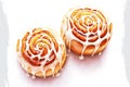 pair of fluffy delicious cinnamon buns with white glaze