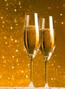 A pair of flutes of champagne on golden abstract background