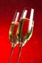 A pair of flutes of champagne red abstract background