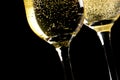 A pair of flutes of champagne tilted with golden bubbles