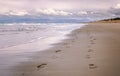 Pair of foot prints on a deserted beach on cloudy evening