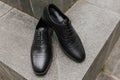 A pair of formal black gentlemen shoes laying on the stair corner, with negative space good for concept print