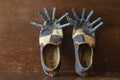 A pair of frayed shoes with clothespins