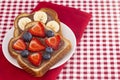 Pair of Fruit and Chocolate Hazelnet Spread Toast on a Red and White Plaid Tablecloth Royalty Free Stock Photo