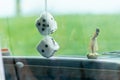 A pair of fuzzy dice hanging from a car`s rear-view mirror Royalty Free Stock Photo