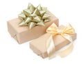 Pair of gift boxes with presents wrapped in kraft paper and with golden light beige bow and gold bow isolated on the white Royalty Free Stock Photo