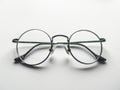 A pair of glasses with green frames on a white surface Royalty Free Stock Photo