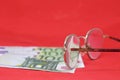 Pair of glasses and money on a red background. Selective focus.. Old banknotes of the former Soviet Union. USSR - rubles Royalty Free Stock Photo