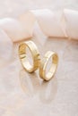 Pair of gold wedding rings on beige background Royalty Free Stock Photo