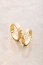 Pair of gold wedding rings on beige background Royalty Free Stock Photo
