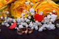 Pair of gold wedding rings and a bouquet of roses Royalty Free Stock Photo