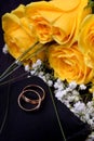 Pair of gold wedding rings and a bouquet of roses Royalty Free Stock Photo