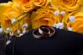 Pair of gold wedding rings and a bouquet of roses Royalty Free Stock Photo