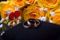 Pair of gold wedding rings and a bouquet of roses Royalty Free Stock Photo