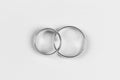 A pair of gold wedding rings on a white background, top view